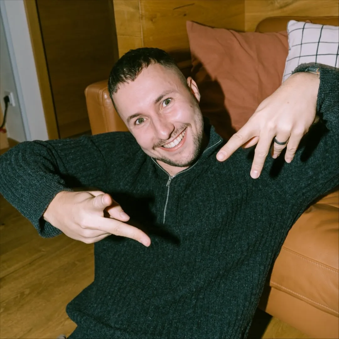Bohuslav Poláček smiling on a sofa